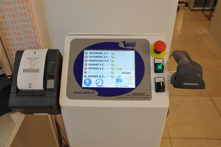 Opérateur utilisant le vestiaire automatique Vens pour restituer un manteau grâce au ticket code-barres unique